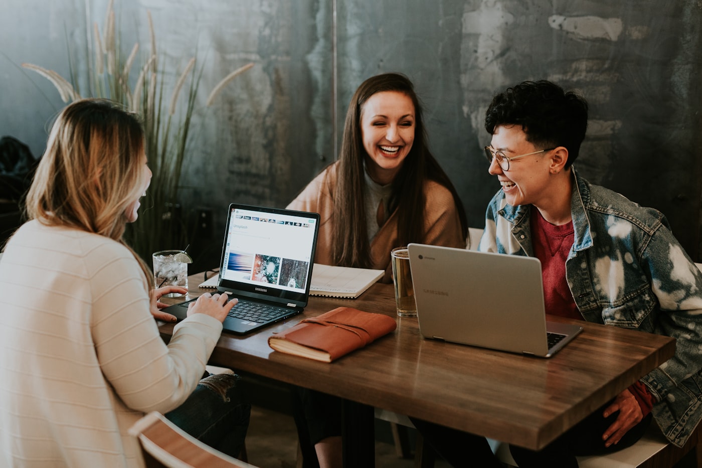 Studenten werken samen aan een opdracht achter hun laptops