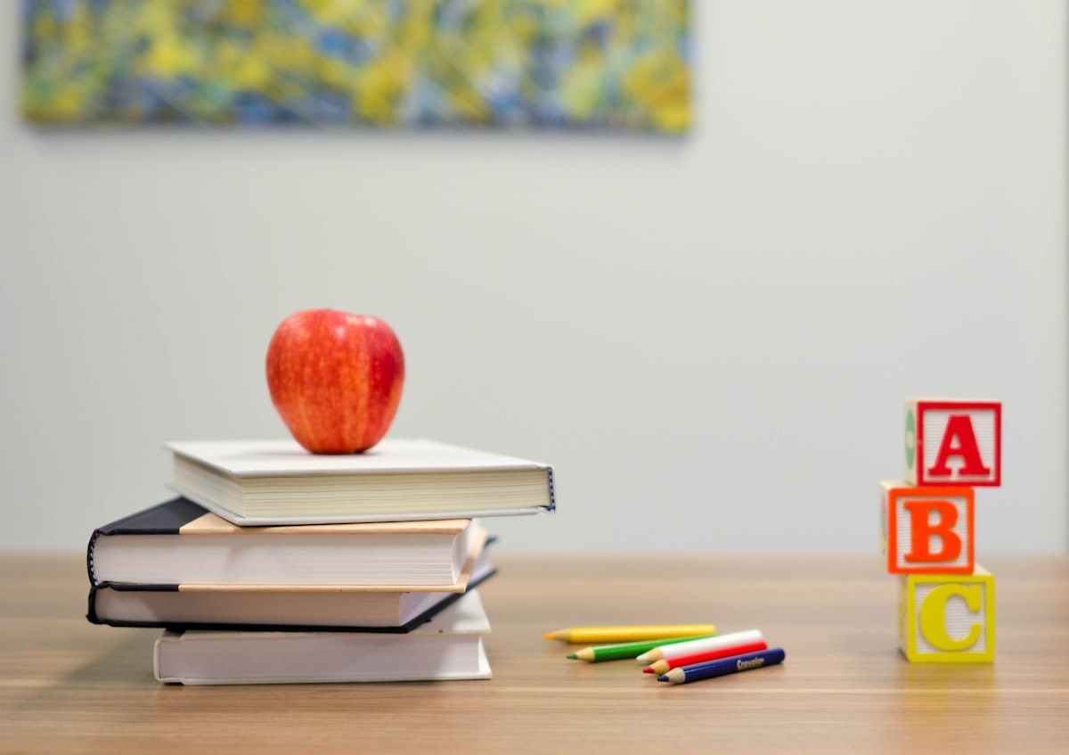 Schoolboeken, kleurpotloden en letterblokken op een tafel